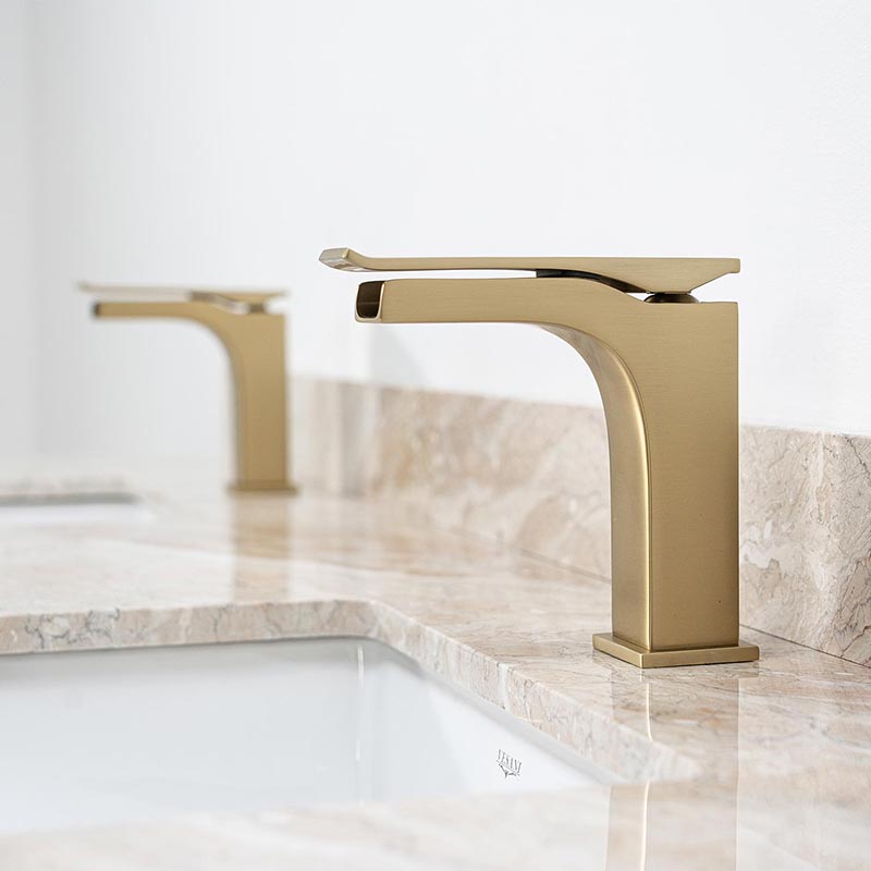 Moderna blandare i mässing moderna blandare i mässing på bänkskiva i beige marmor